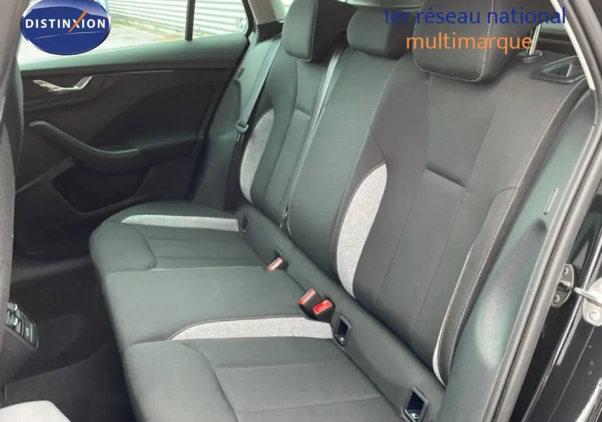 Vue intérieure côté droit montrant la banquette arrière en tissu gris noir d'une Skoda Scala 2025 noir magique métal.