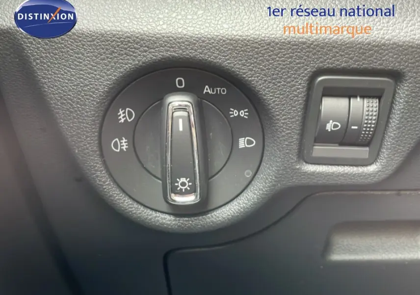 Gros plan sur le sélecteur de phares et le réglage d’intensité lumineuse intérieur d’une Skoda Scala noire.