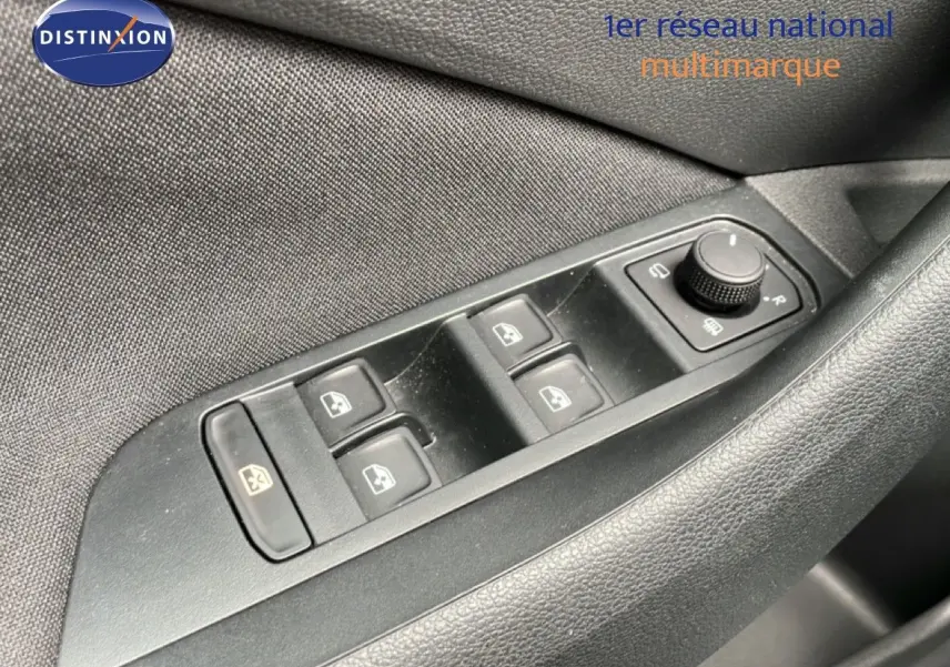 Gros plan sur les commandes des vitres électriques et réglage des rétroviseurs côté conducteur d’une Skoda Scala noir magique métal.