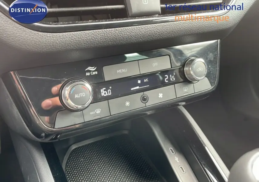 Gros plan sur la console centrale de la Skoda Scala noire, mettant en valeur les commandes de climatisation digitale.