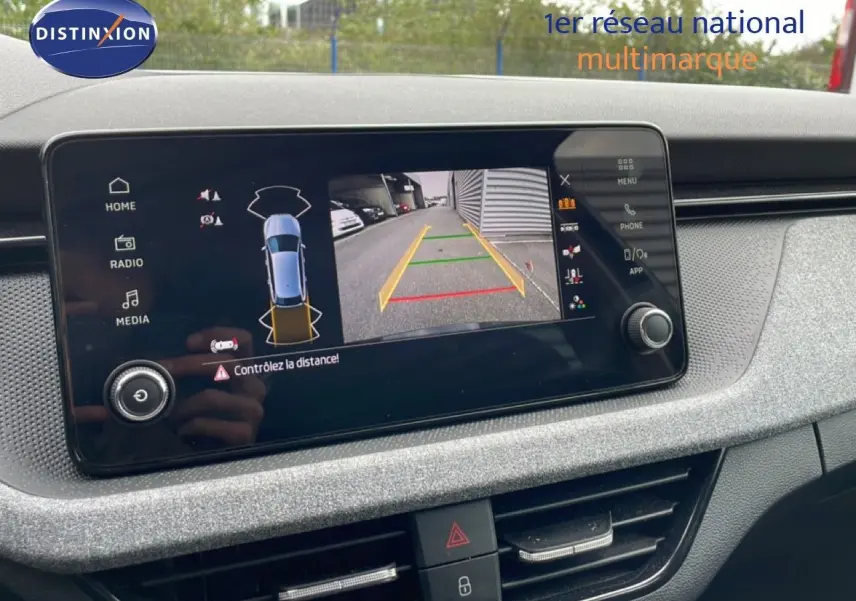 Écran central de la Skoda Scala 2025 montrant la caméra de recul avec affichage des distances, intérieur gris noir.