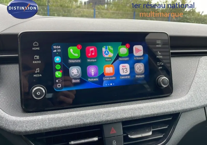 Écran tactile central de la Skoda Scala 2025 affichant Apple CarPlay, entouré d'une console grise texturée.