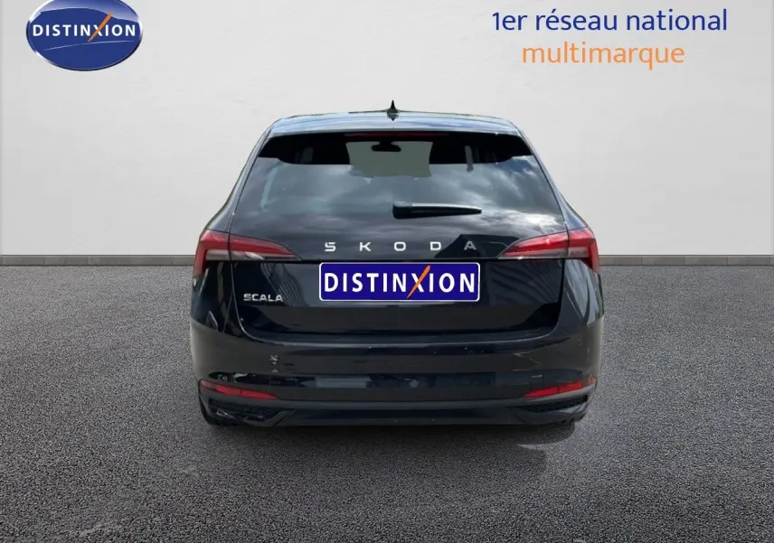 Vue arrière d'une Skoda Scala noire métal, avec feux arrière allongés et logo distinctif bien visible.