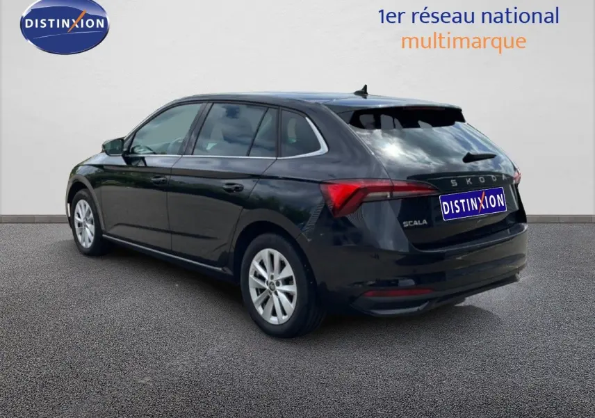 Vue 3/4 arrière droite d'une Skoda Scala noire métallique, avec feux arrière allongés et jantes argentées.