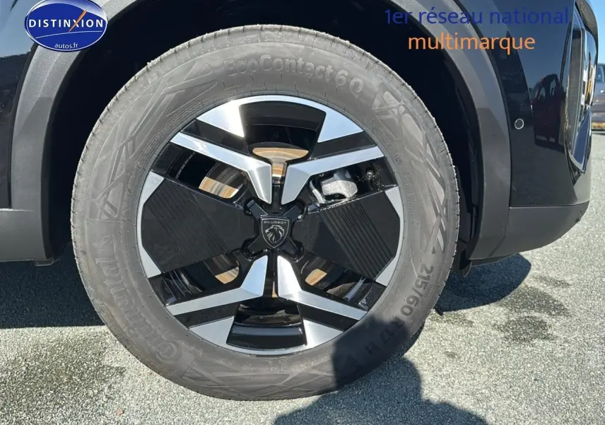 Gros plan sur la roue avant gauche noire avec jante alu au design moderne du Peugeot 2008 noir 2025.