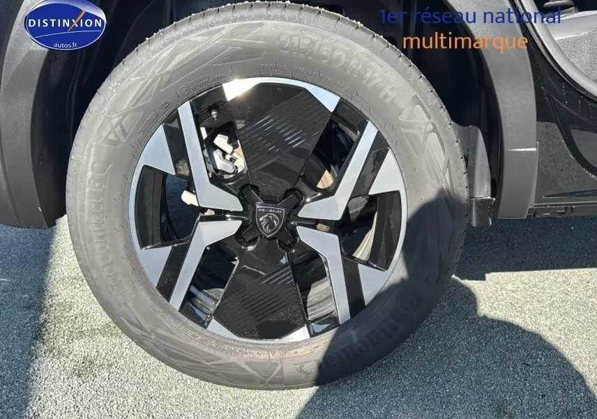 Gros plan sur la jante alu noire et grise du côté avant droit du Peugeot 2008 noir 1.2 hybrid 145 allure e-dcs6 2025