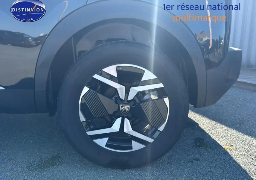 Gros plan sur la roue arrière droite noire du Peugeot 2008 1.2 hybrid 145 allure e-dcs6 avec jante alu design.