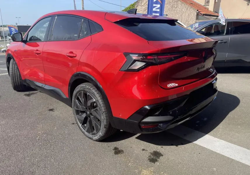 Vue 3/4 arrière droite du Renault Rafale 2025 rouge flamme avec toit noir et jantes noires diamantées.