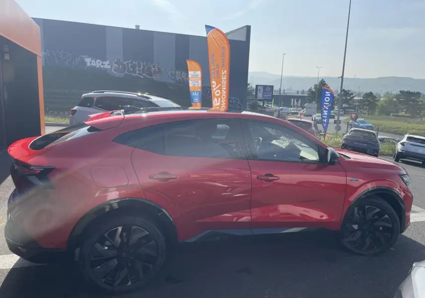 Profil côté gauche d'un Renault Rafale rouge à toit noir avec jantes noires et badge Esprit Alpine visible.