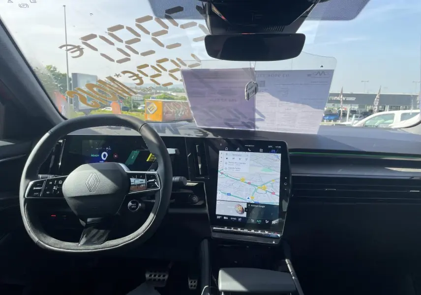 Vue intérieure avant du tableau de bord et volant Renault Rafale rouge, avec écran tactile vertical et affichage numérique.