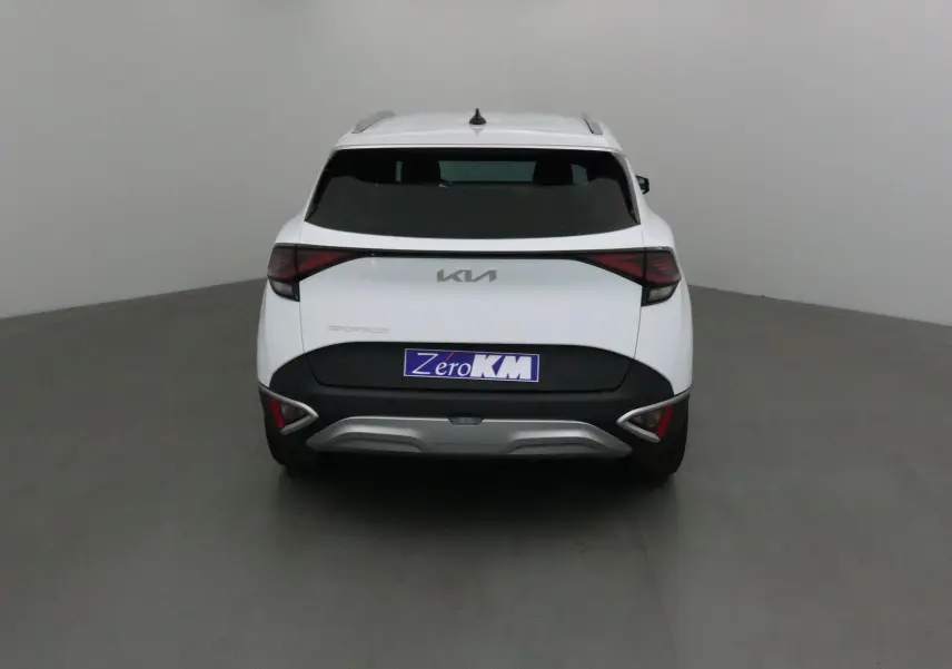 Vue arrière du SUV blanc KIA SPORTAGE 2025 avec feux LED et logo KIA moderne sur fond neutre.