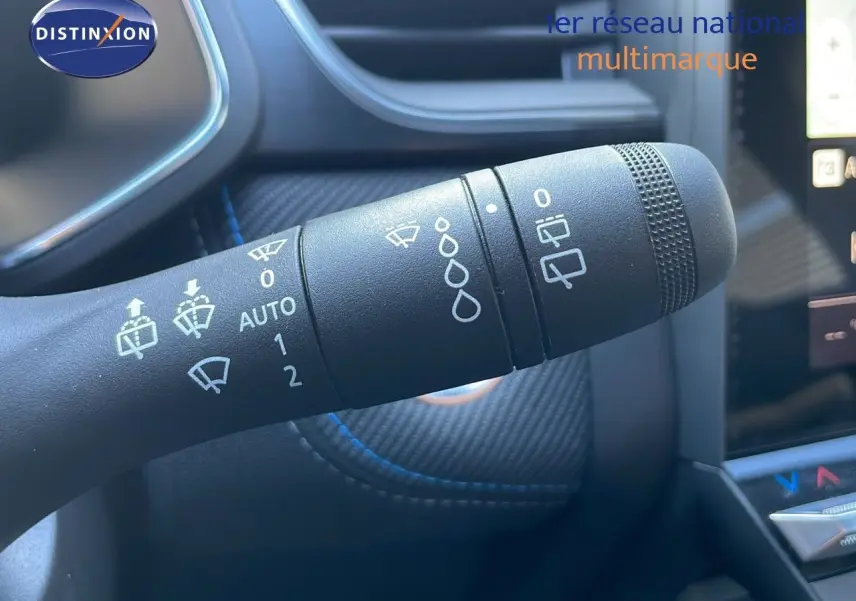 Gros plan sur la commande d’essuie-glace du Renault Captur E-Tech hybride 2025, intérieur noir avec surpiqûres bleues.