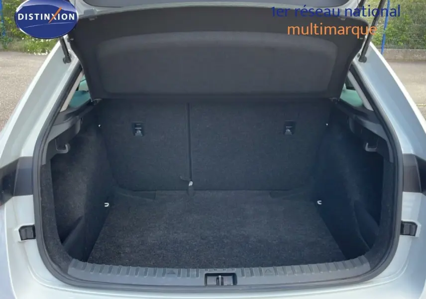 Coffre ouvert d'une Skoda Scala blanc glacier, vue arrière montrant l'espace de chargement vide et doublé de tissu noir.