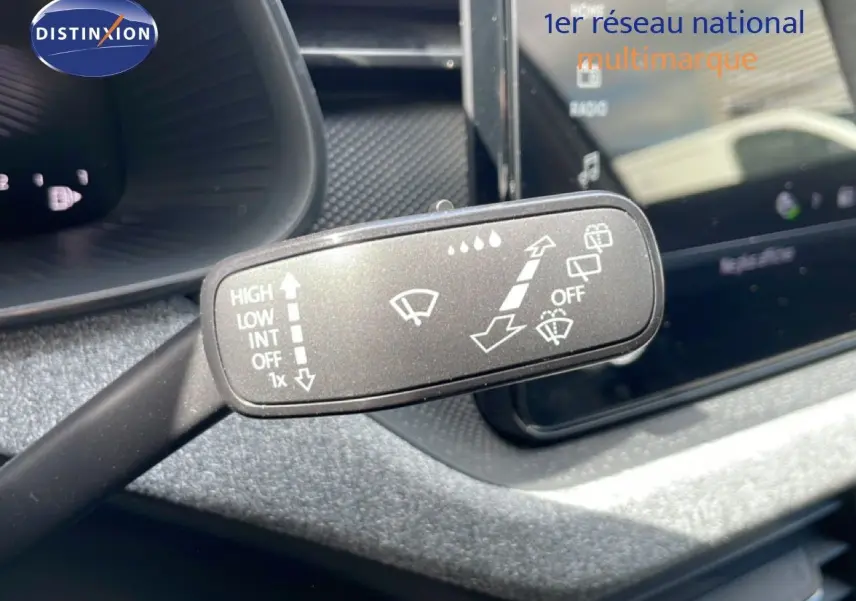 Gros plan sur la commande des essuie-glaces dans l'habitacle gris noir d'une Skoda Scala blanc glacier.