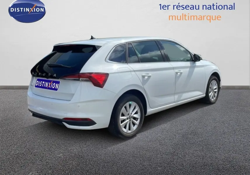 Vue 3/4 arrière droite d'une Skoda Scala blanche glacier avec vitres teintées et jantes alliage 16 pouces.