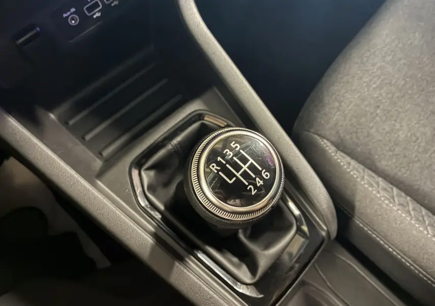 Gros plan sur le levier de vitesses manuel noir de la Renault Clio 1.5 BlueDCI Business 2022 avec intérieur tissu gris.