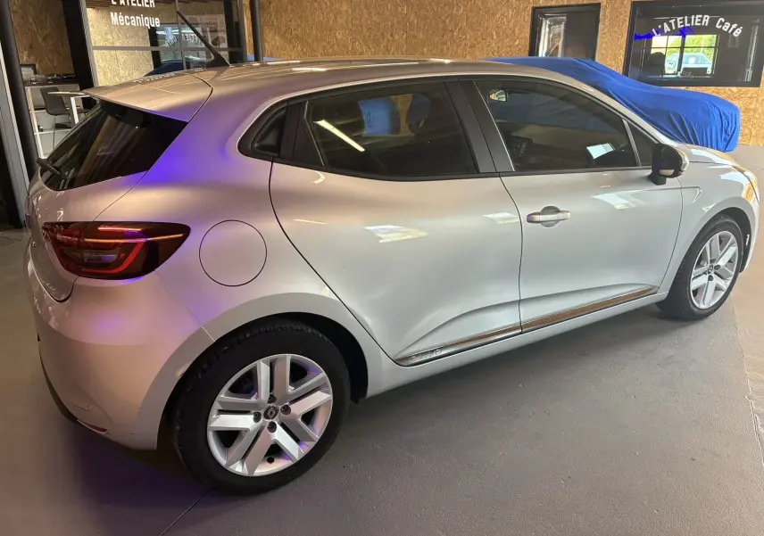 Renault Clio 1.5 BlueDCI Business gris vue côté droit en intérieur, soulignant la ligne fluide et les jantes alliage.