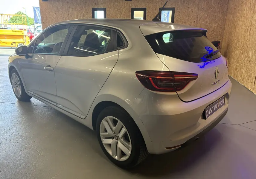 Renault Clio 1.5 BlueDCI Business gris vue 3/4 arrière droit dans un garage avec éclairage intérieur.