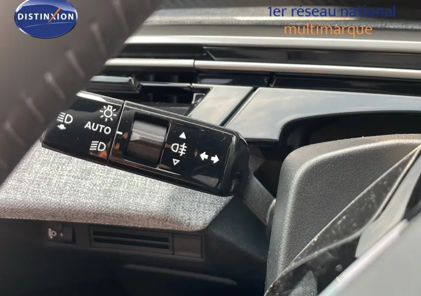 Gros plan sur la commande des feux et clignotants côté gauche du volant dans un Peugeot 3008 gris Artense 2025.