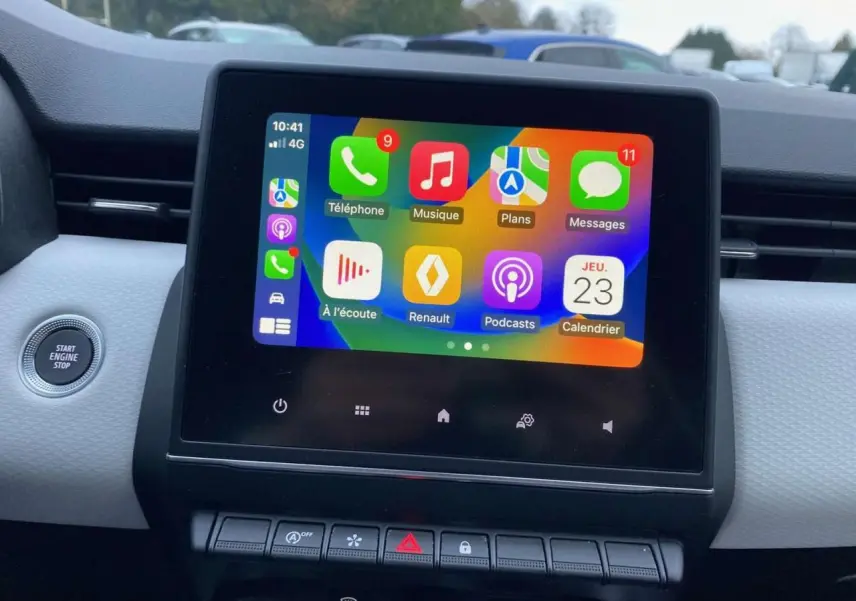 Écran tactile multimédia 7 pouces affichant Apple CarPlay dans l'habitacle d'une Renault Clio blanche.