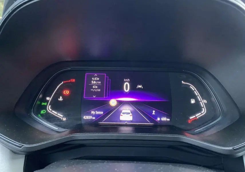 Tableau de bord numérique de Renault Clio blanche 2023 affichant vitesse, consommation et autonomie.