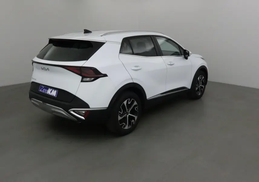 KIA SPORTAGE blanc vu en 3/4 arrière droit, avec jantes noires et feux arrière LED distinctifs.