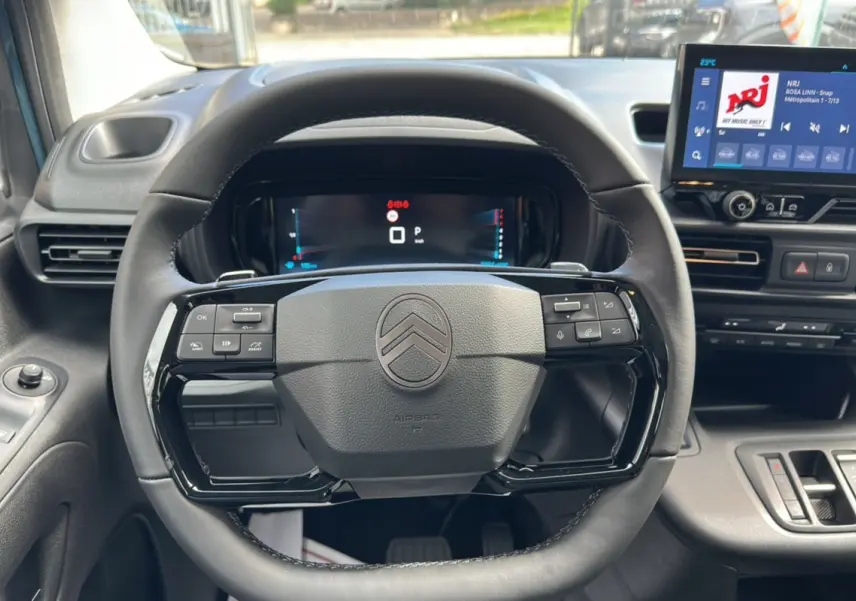 Vue intérieure centrée sur le volant du Citroën Berlingo 2025 Kiama blue avec tableau de bord numérique et écran tactile.