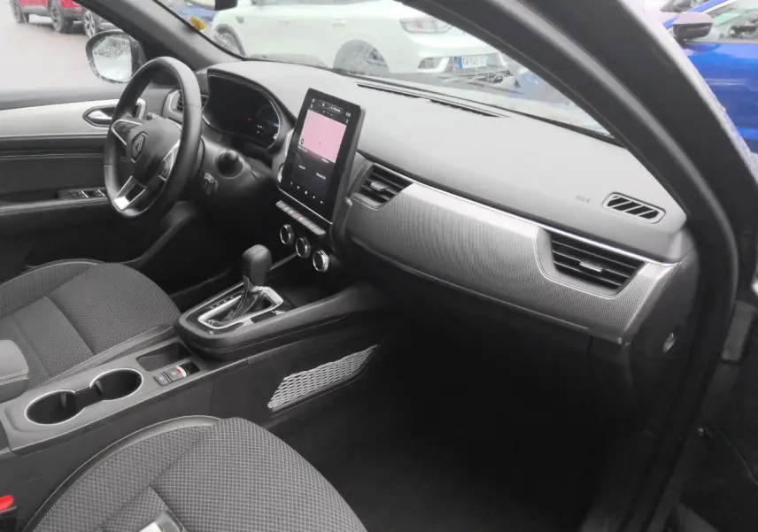Intérieur avant droit du Renault Arkana 2024 gris métal, tableau de bord moderne avec écran tactile vertical.
