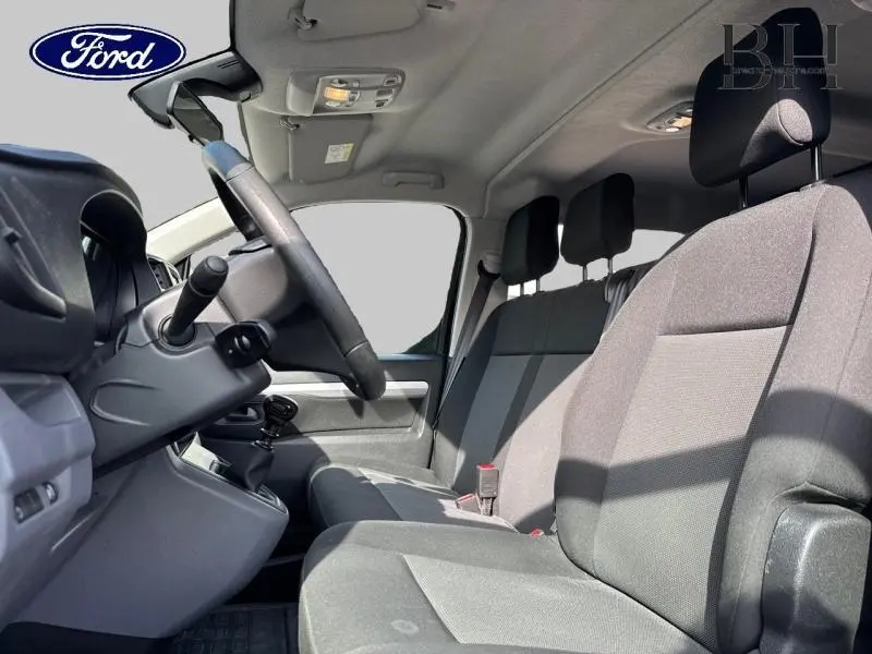 Intérieur avant du Peugeot Expert Fourgon noir, vue côté conducteur montrant les sièges et le volant.