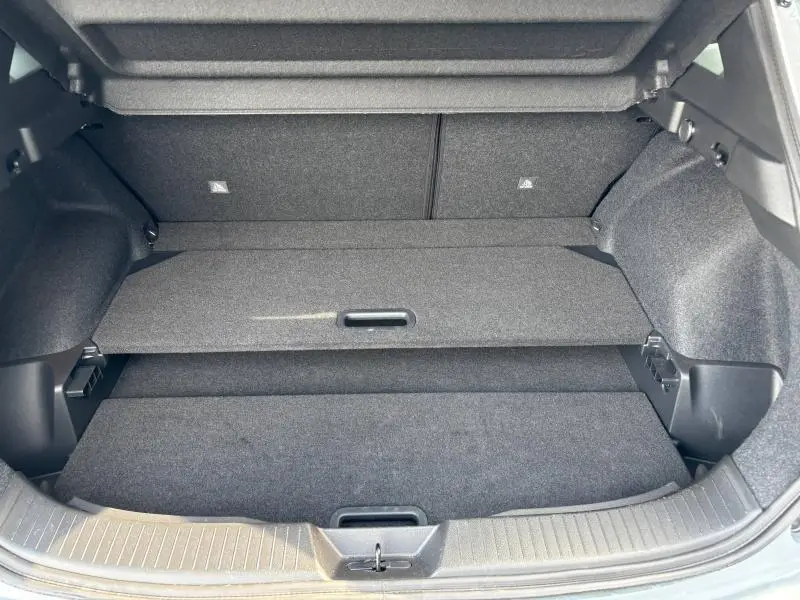 Coffre ouvert du Nissan Qashqai e-POWER 2024, vue intérieure montrant le plancher de coffre modulable gris foncé.