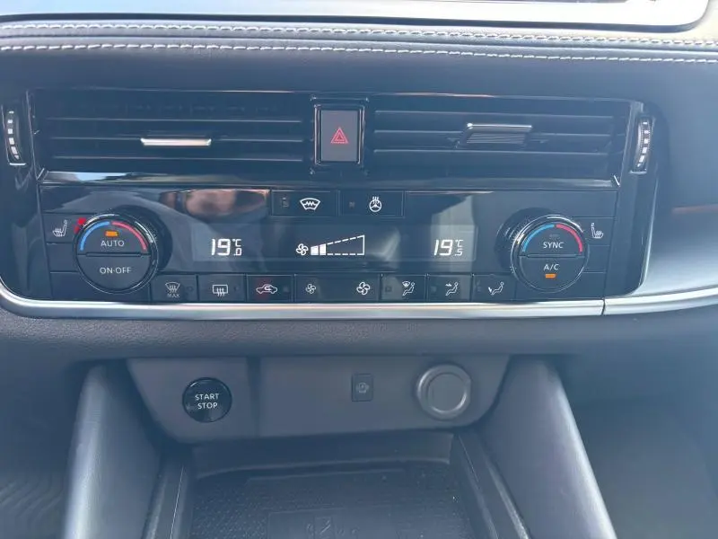 Tableau de bord du Nissan Qashqai e-POWER 2024 montrant la climatisation automatique bi-zone à 19°C et commandes tactiles noires.