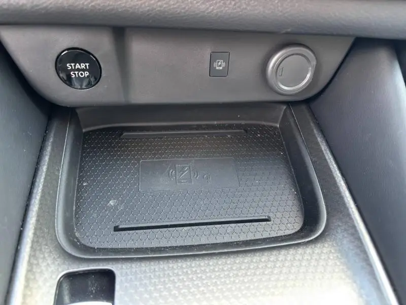 Gros plan sur la zone de recharge sans fil noire et le bouton Start/Stop du Nissan Qashqai e-POWER 2024.