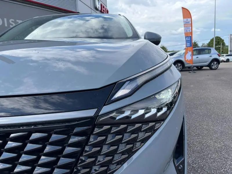 Gros plan sur le phare avant droit et la calandre en gris Argile du Nissan Qashqai e-POWER 2024, détails LED visibles.