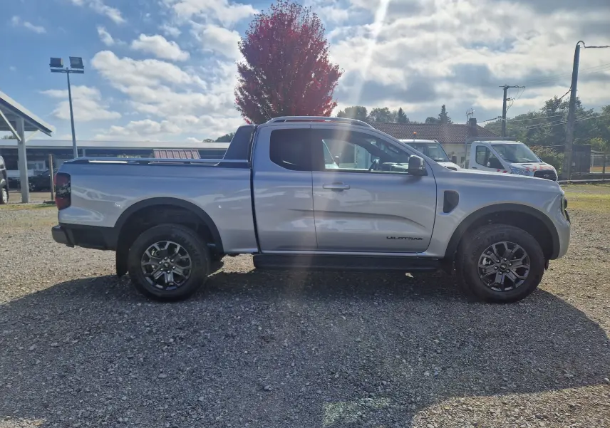 Ford Ranger Super Cabine Wildtrak gris iconic vu de profil côté gauche, avec jantes noires et benne ouverte.