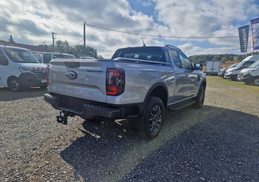 Ford Ranger Super Cabine gris iconic vu en 3/4 arrière droit, avec attelage et protections de benne visibles.
