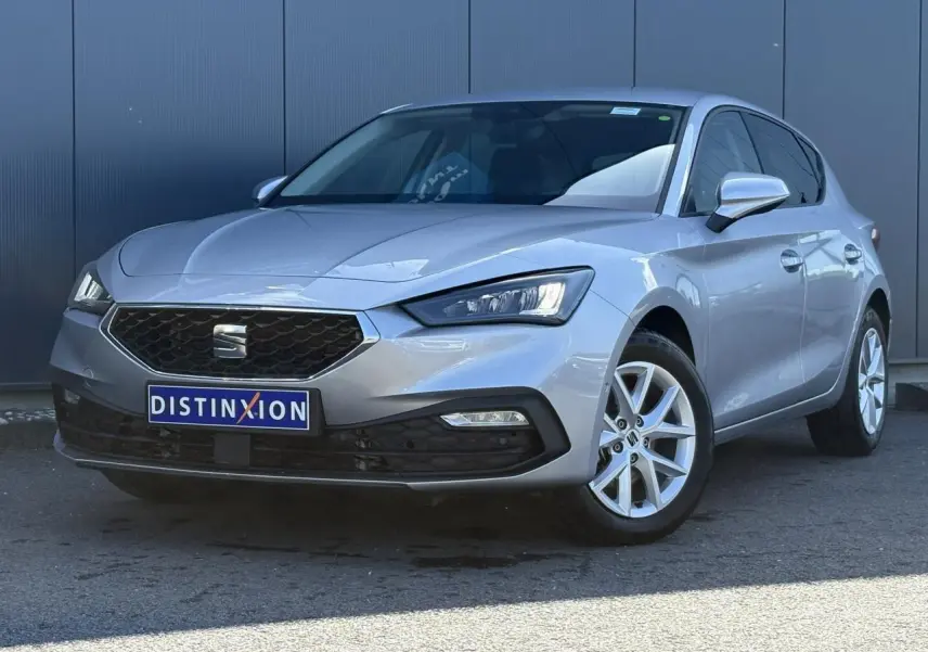 SEAT Leon gris argent vue 3/4 avant droit, jantes alliage 16 pouces et calandre hexagonale distinctive.