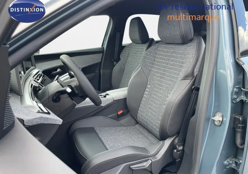 Vue intérieure côté conducteur du Peugeot 3008 Hybrid 2025 en bleu Ingaro Metal, sièges tissu et cuir gris avec surpiqûres.