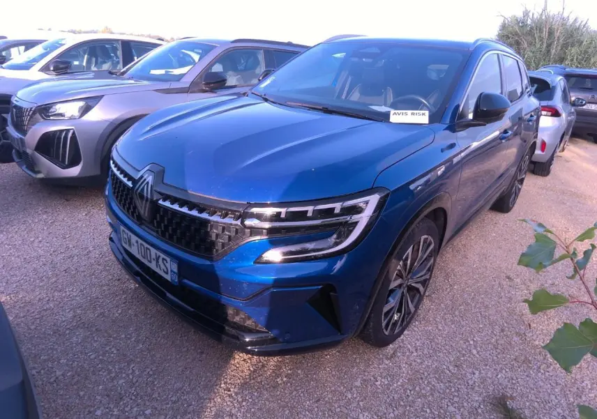 Renault Austral bleu métal foncé en 3/4 avant droit, avec calandre damier ice black et jantes alliage 20 pouces.