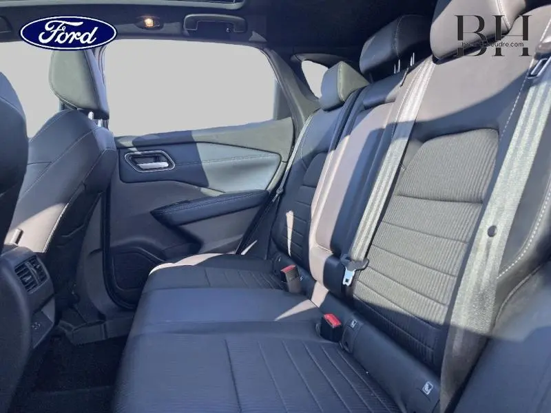 Vue latérale intérieure des sièges arrière noirs du Nissan Qashqai 1.3 Mild Hybrid Tekna 2022, avec ceintures visibles.