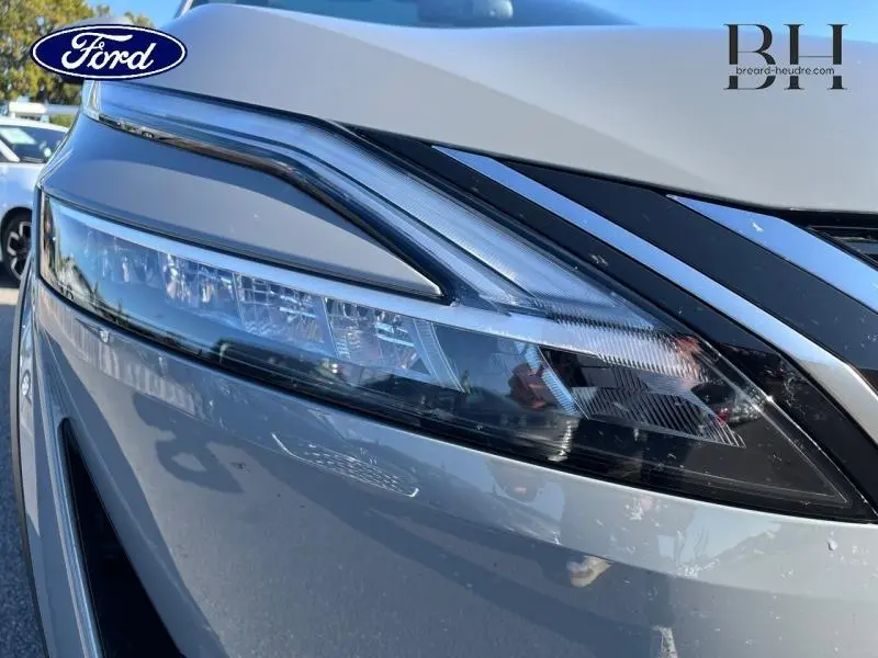 Gros plan sur le phare avant droit gris argile du Nissan Qashqai 1.3 Mild Hybrid Tekna 2022 avec détails LED distinctifs.