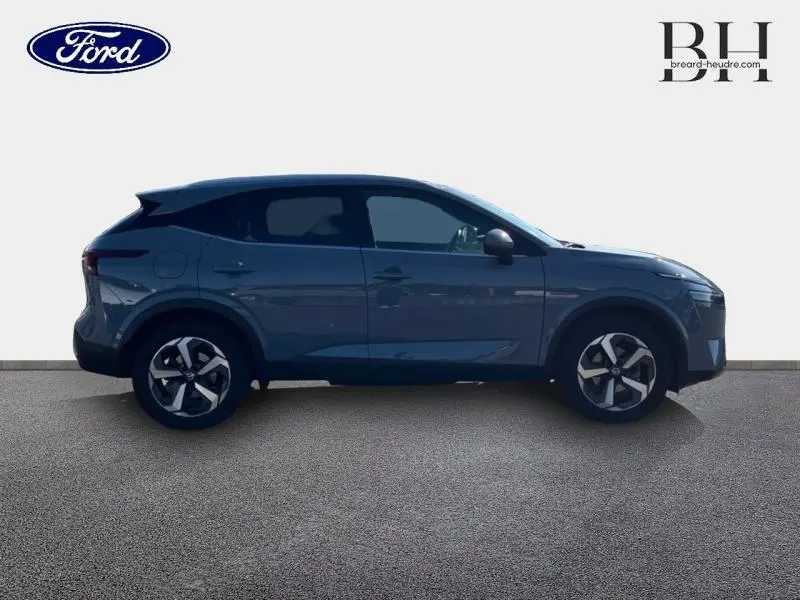 Profil droit d'un Nissan Qashqai 1.3 Mild Hybrid 140ch Tekna gris Argile, avec jantes alliage et vitres teintées.