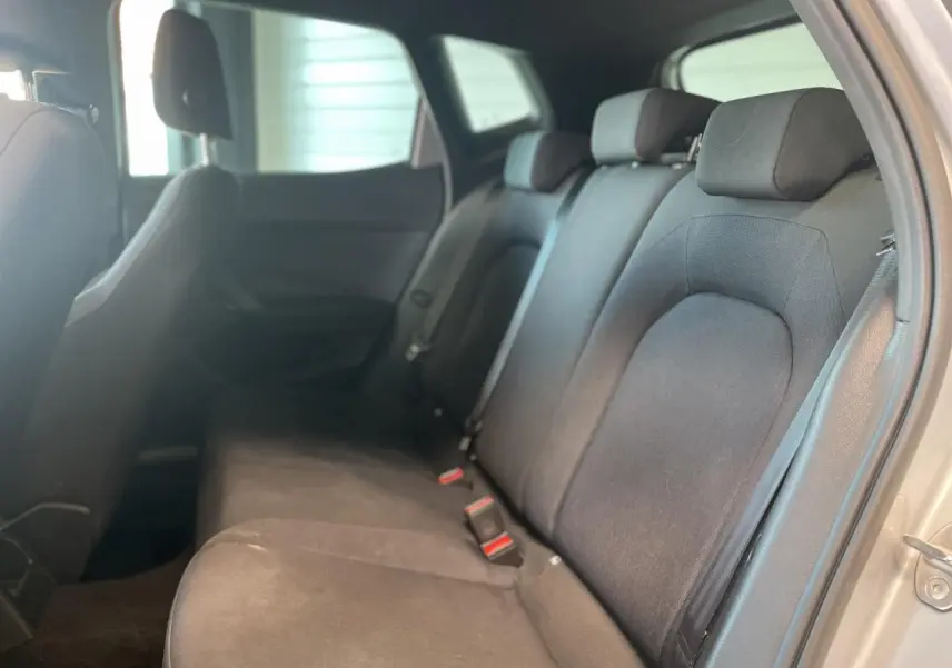 Vue latérale droite de la banquette arrière textile noire du SEAT Arona 2024, avec appuie-têtes et ceintures visibles.