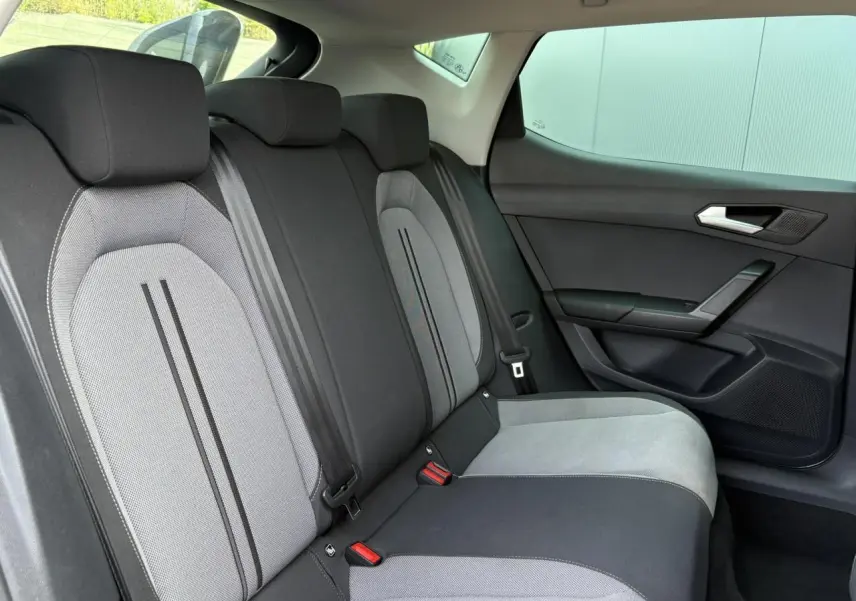 Vue latérale droite de la banquette arrière gris clair et foncé du SEAT LEON 2.0 TDI 150 DSG Style 2024 avec vitres surteintées.