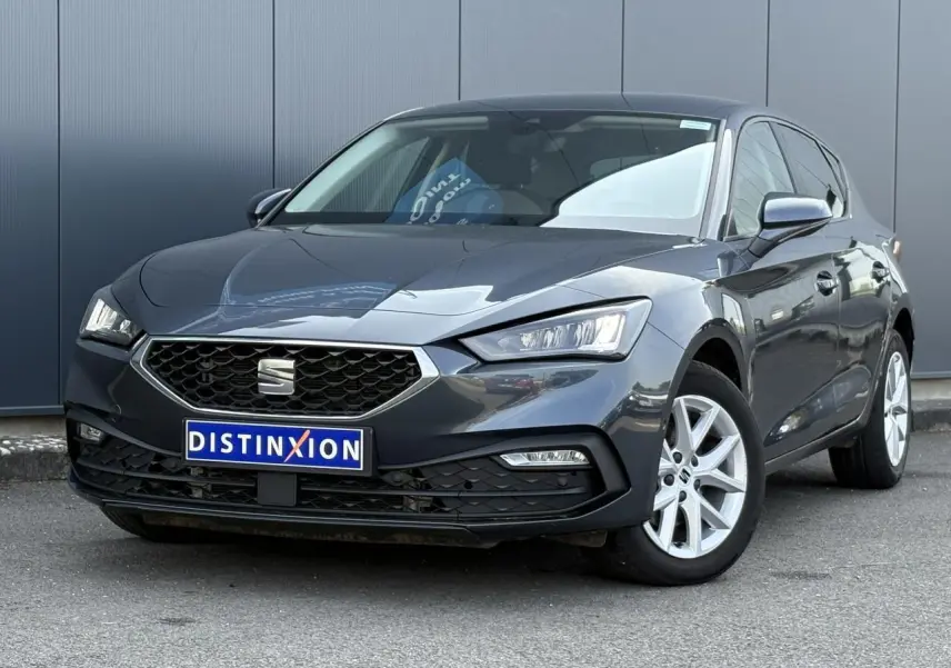 SEAT Leon 2024 gris magnétique en 3/4 avant droit, avec calandre hexagonale et jantes alliage 16 pouces.