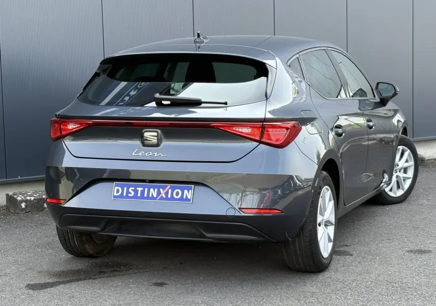 Vue 3/4 arrière droite d'une SEAT Leon 2024 gris magnétique avec feux arrière LED et vitres surteintées.