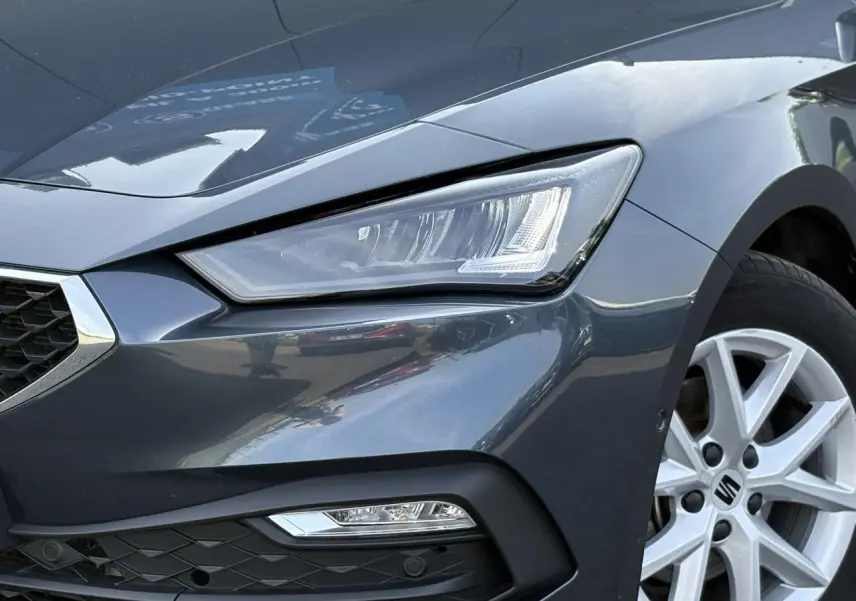 Gros plan sur l'avant droit gris magnétique du SEAT LEON 2024, mettant en valeur le phare LED et la jante alliage 16 pouces.