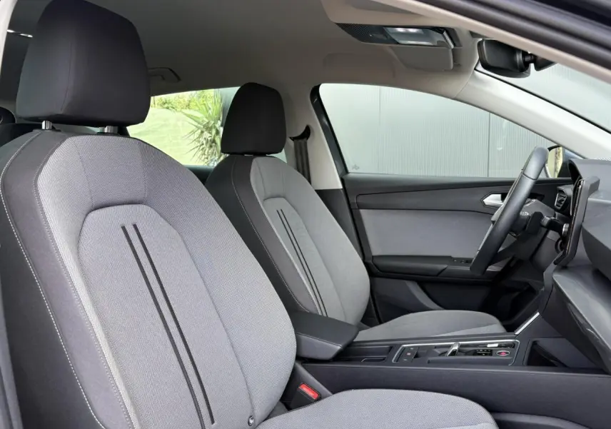 Vue intérieure côté conducteur du SEAT LEON 2.0 TDI 150 DSG Style 2024 avec sièges gris et volant cuir multifonction.