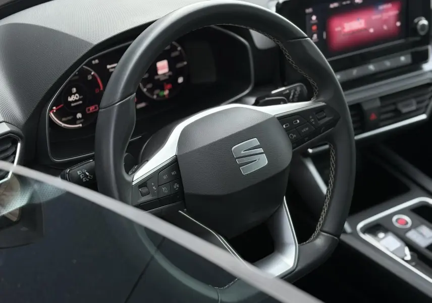 Volant cuir multifonction de la SEAT LEON 2.0 TDI 2024 vu de près avec tableau de bord numérique et console centrale moderne.