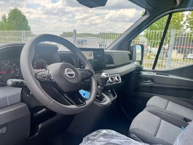 Vue intérieure côté conducteur du Nissan Interstar Fourgon 2025, tableau de bord moderne avec volant multifonction et levier de vitesses manuel.