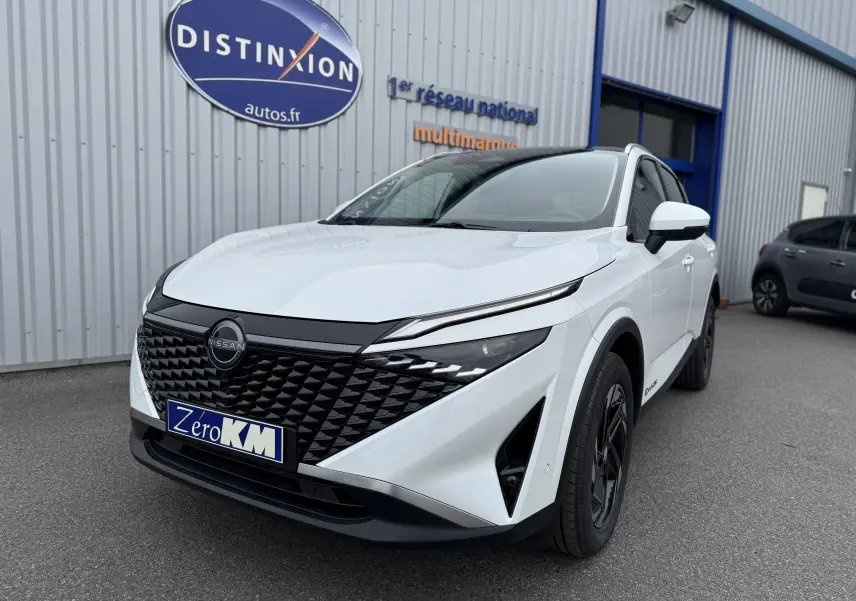 Nissan Qashqai blanc nacré métal vu en 3/4 avant droit, avec calandre noire et phares LED fins.
